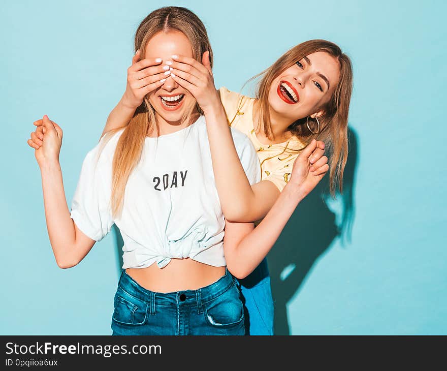 Girl surprising her female best friend. Model covering her eyes and hugging  from behind. Two surprised girls. Women having fun and showing face emotions. Girl surprising her female best friend. Model covering her eyes and hugging  from behind. Two surprised girls. Women having fun and showing face emotions