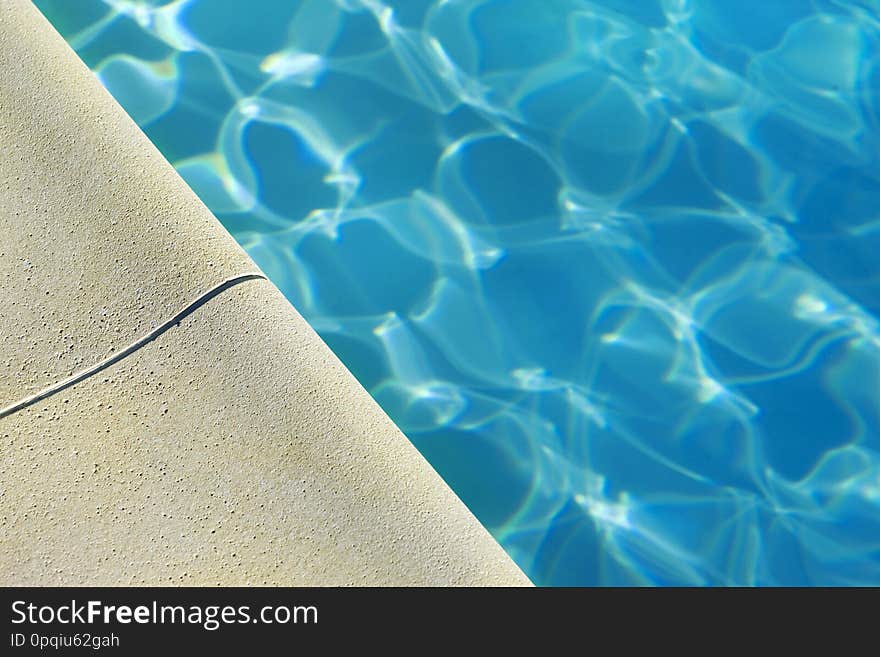 Close up of a swimming pool in Summer, edge, holidays, bath, water, relaxing, blue, architecture, stoned, detail, macro, macrophotography, leisure, transparency, reflection