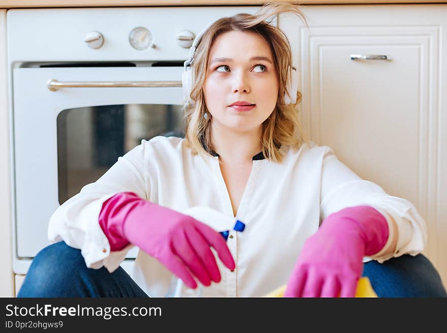 So tired. Nice young woman sassing near the oven while being tired after cleaning the kitchen. So tired. Nice young woman sassing near the oven while being tired after cleaning the kitchen