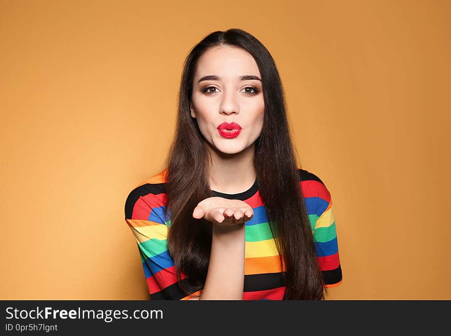 Portrait of beautiful young woman on colorful background