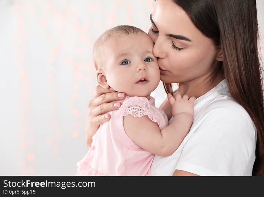 Portrait of happy mother with her baby against blurred lights