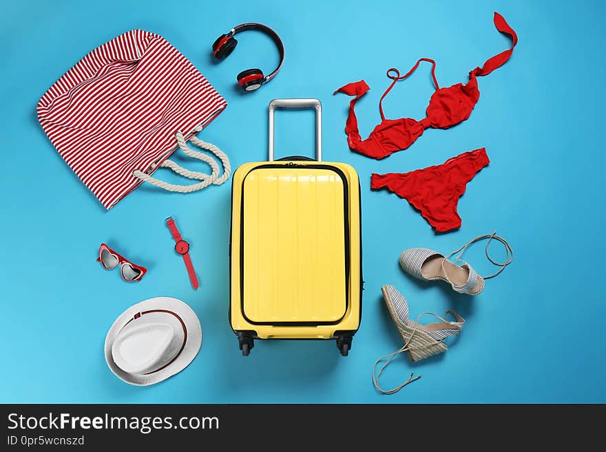 Flat lay composition with suitcase and accessories on color background. Summer vacation