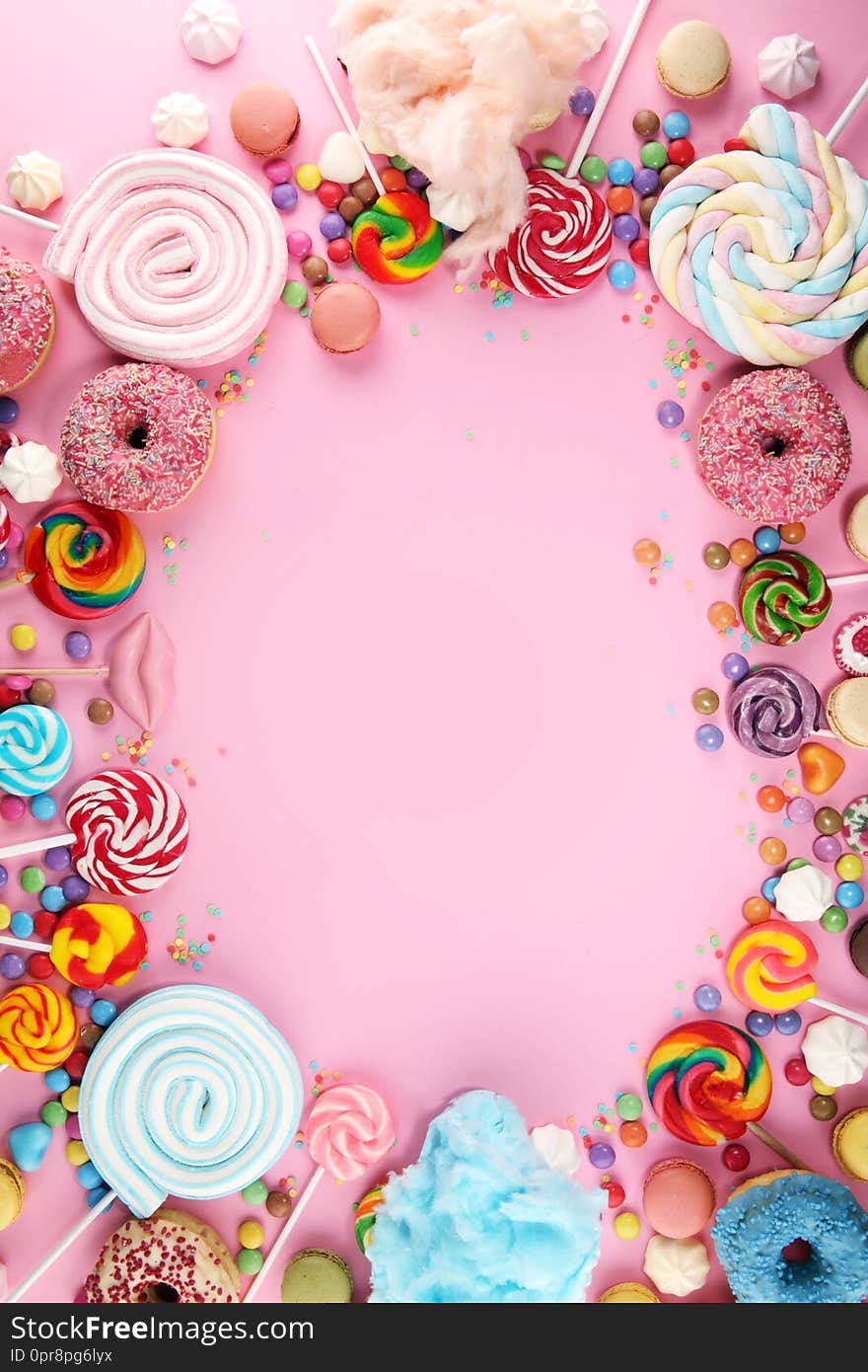 Candies with jelly and sugar. colorful array of different childs sweets and treats on pink background