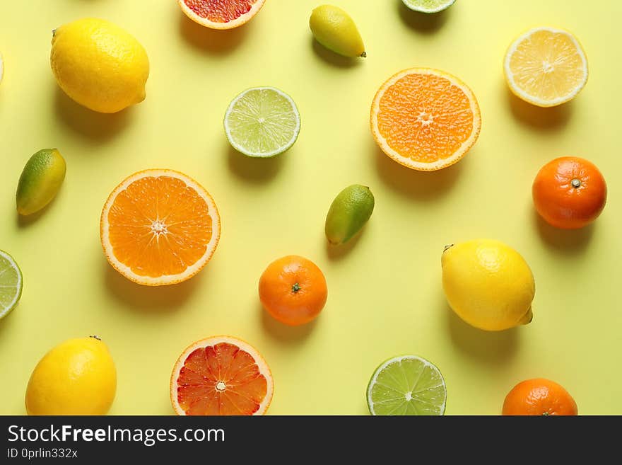 Different citrus fruits on color background