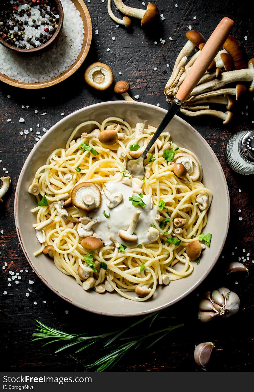 Pasta with mushrooms, sauce, herbs and spices in bowl