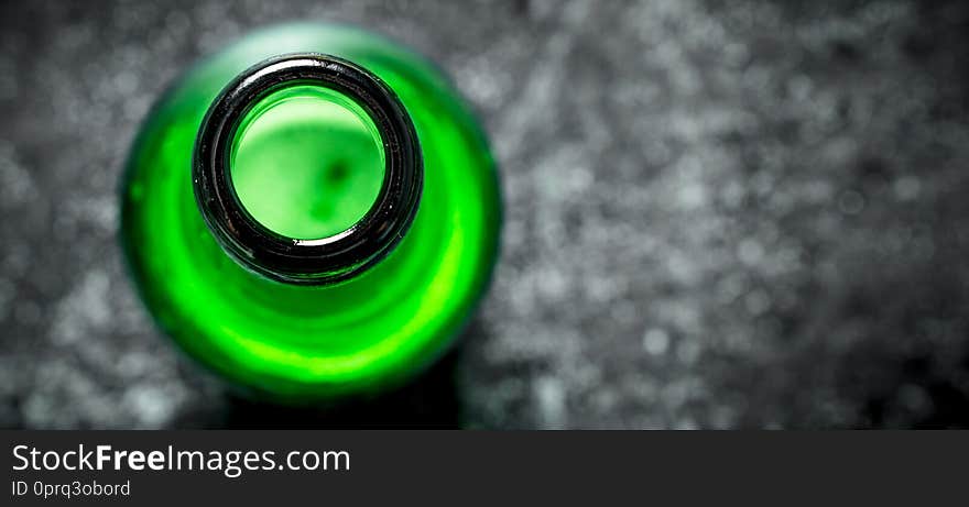 Open bottle of beer. On black rustic background