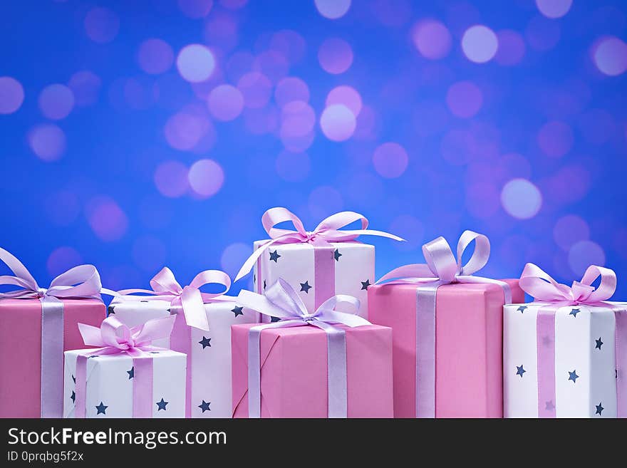 Stylish Boxes With Gifts In White Paper In The Stars, Decorated With Pink Satin Ribbon With Bows.