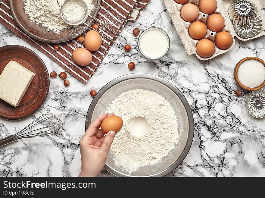 Close-up shot. Top view of a baker cook place, hands are working with a raw dough on the marble table background.