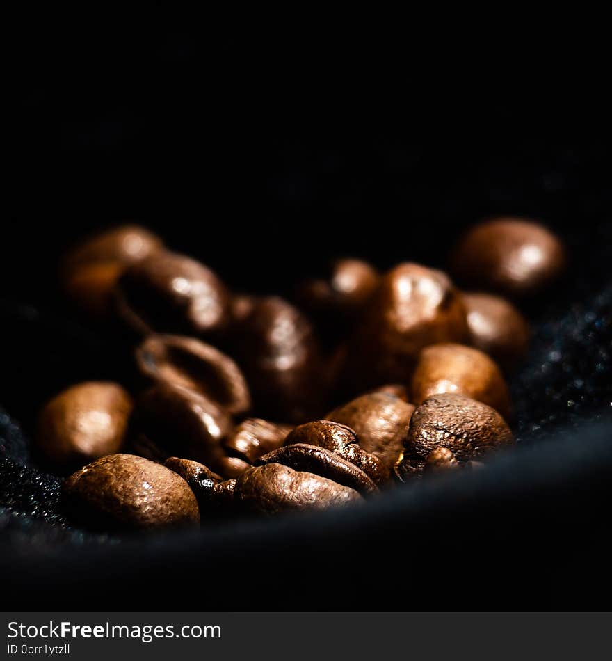 Dark background with grains of coffee is soft focus