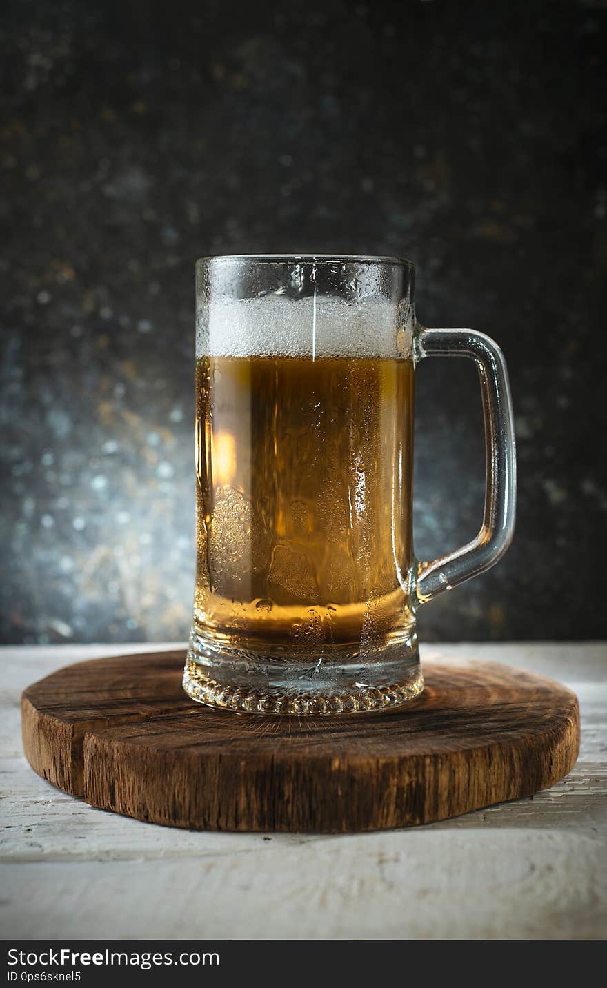 Mug of fresh light beer on wooden background