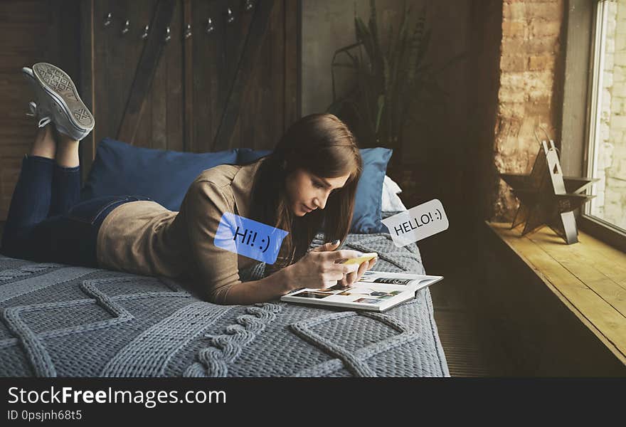 Happy young woman bed at home on couch texting her friend