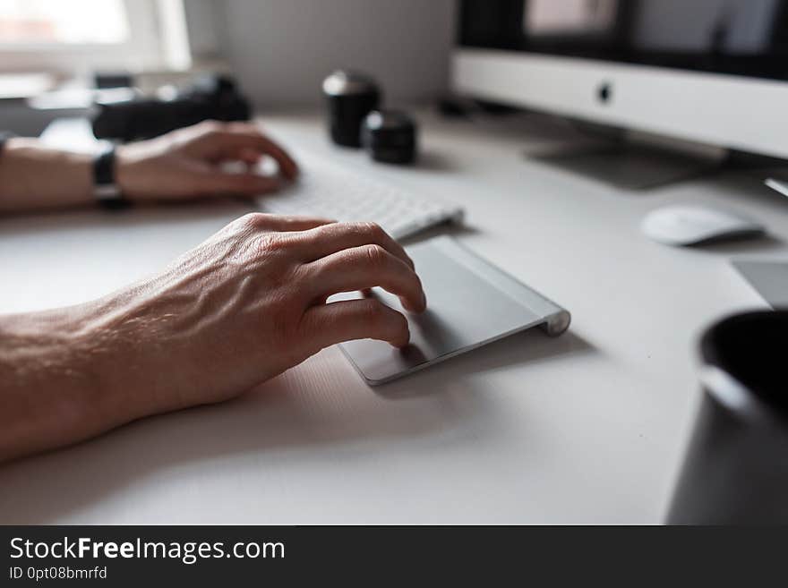 Professional designer man working at the computer. Closeup of male hands  and white desktop.