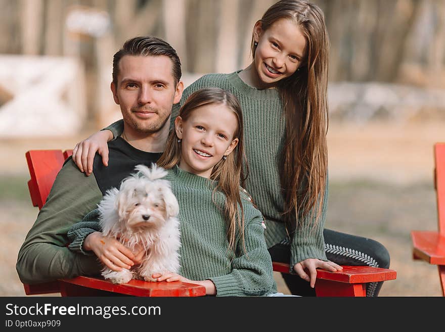 Mother And Daughter Playing With Dog Outdoors