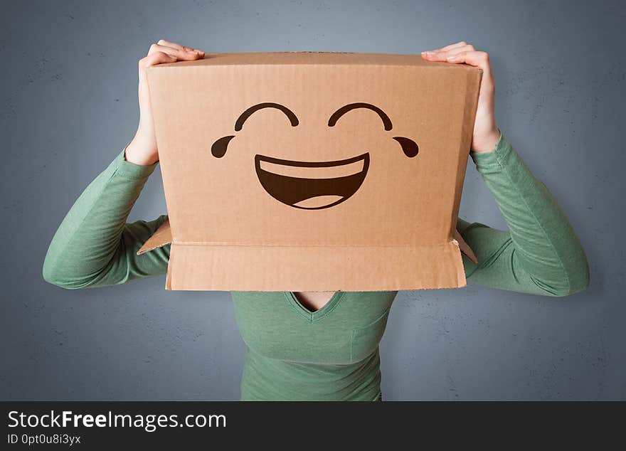 Funny woman wearing cardboard box on her head with smiley facen. Funny woman wearing cardboard box on her head with smiley facen