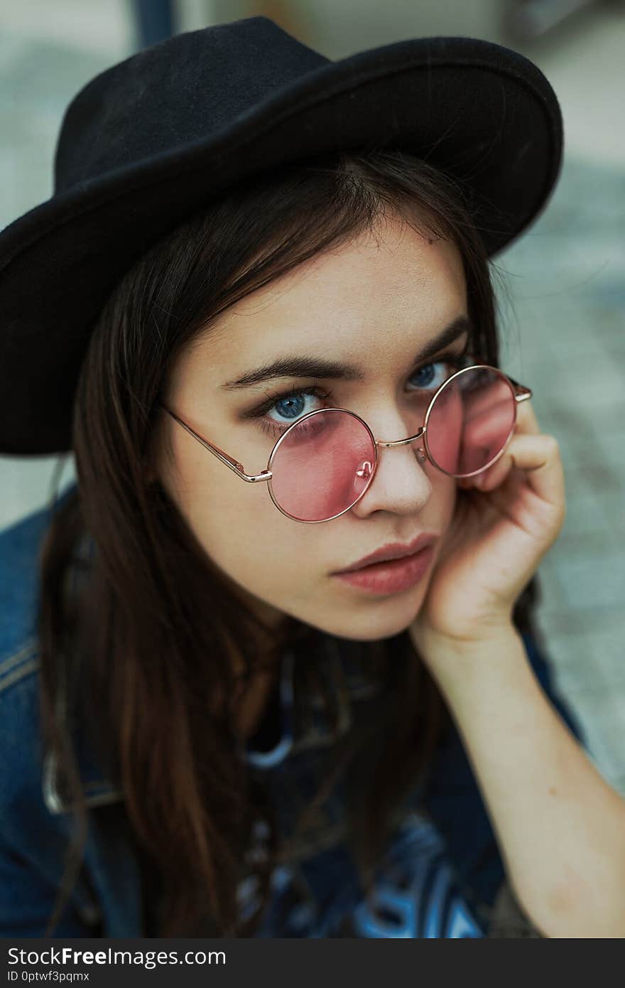 Portrait of attractive young woman in stylish glasses and hat