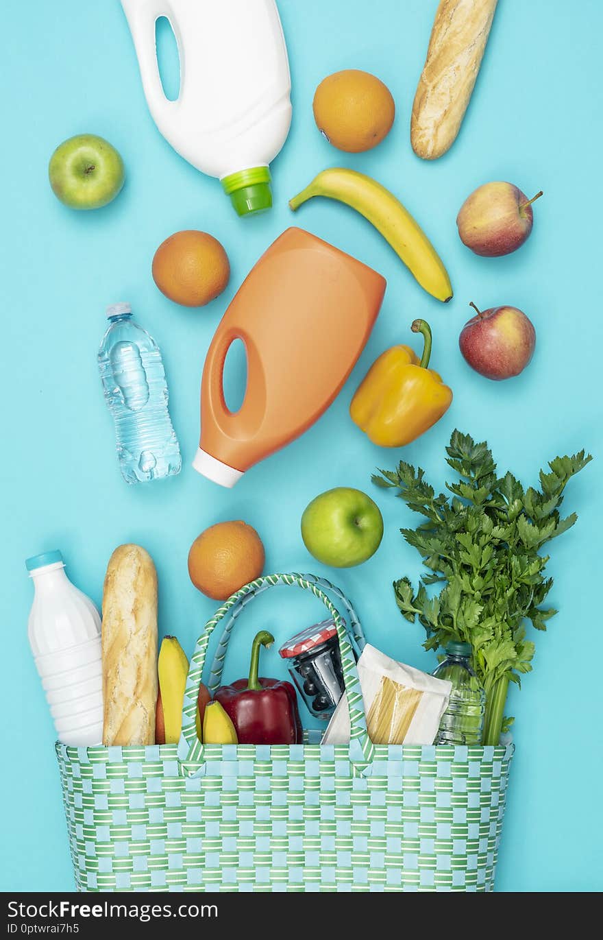 Fresh vegetables and grocery products falling into a reusable shopping bag. Fresh vegetables and grocery products falling into a reusable shopping bag
