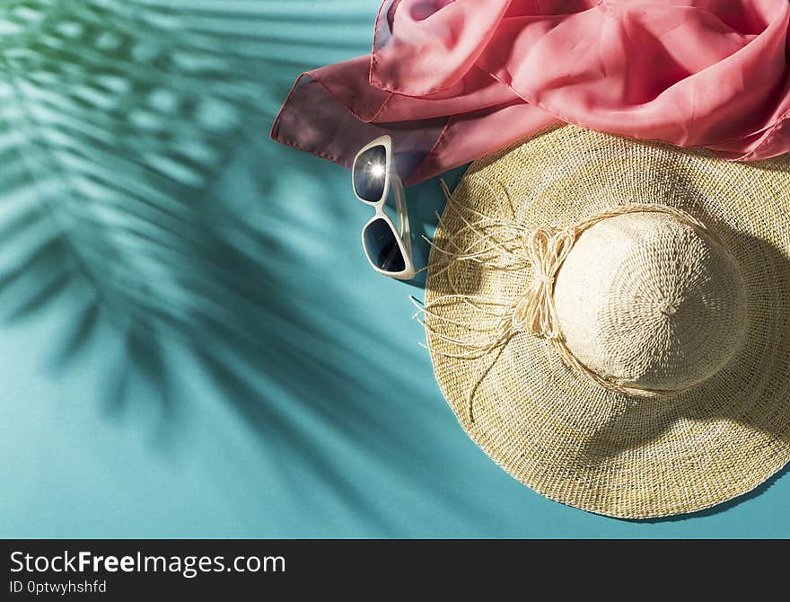 Summer beach vacations and tropical destinations: straw hat, sunglasses, scarf and palm leaves shadow, blank copy space