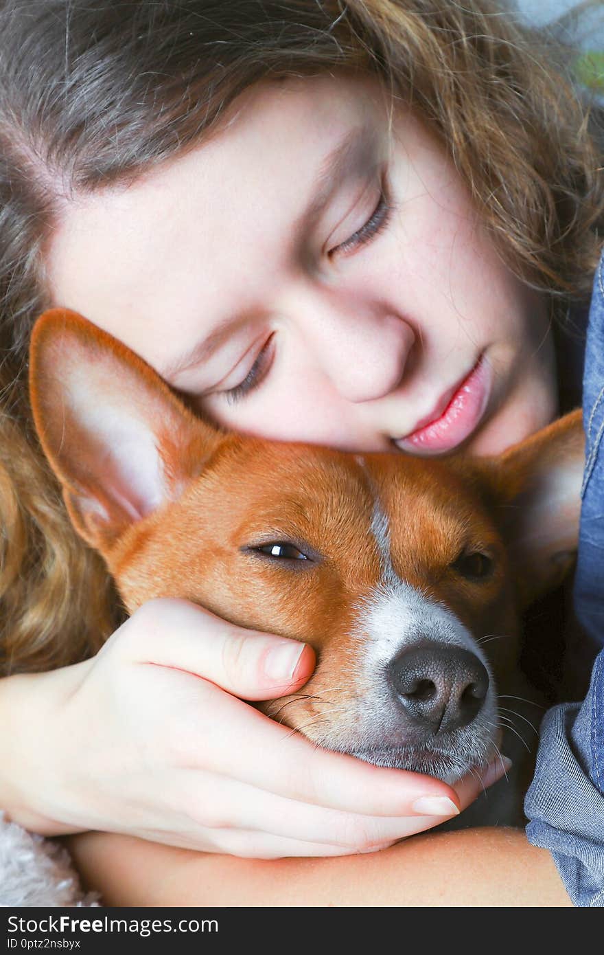 The girl hugs the basenji dog