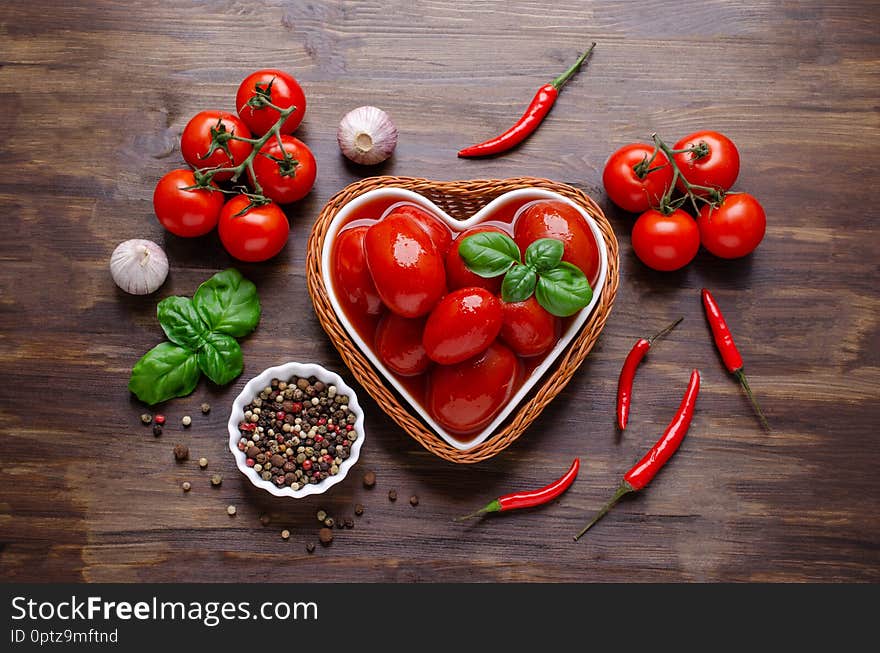 Whole canned tomatoes in their own juice with spices on a dark wooden background. Selective focus