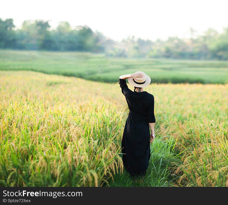 Woman in black dress and straw hat.