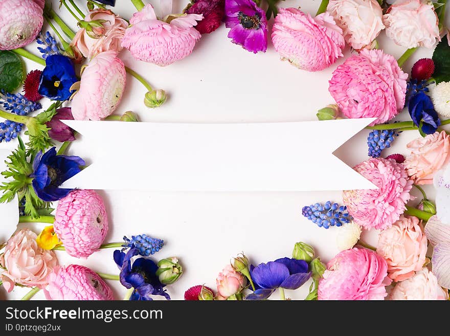 Flowers composition. Frame made of roses, ranunculus and orchids flowers on white background. Flat lay, top view scene. Flowers composition. Frame made of roses, ranunculus and orchids flowers on white background. Flat lay, top view scene.