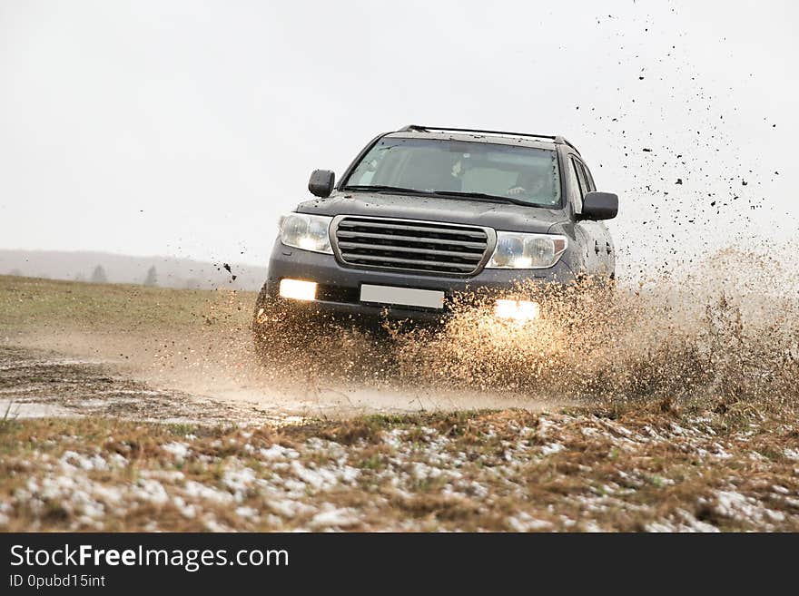 Off-road car driving through a puddle