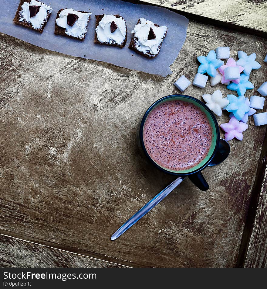 Cocoa, chocolate and colored sweets on the table. Cocoa, chocolate and colored sweets on the table