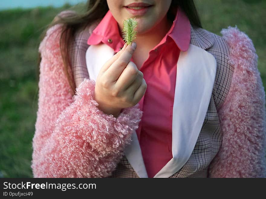 A teenage girl holding an adler flower covered with pollen, outdoor cropped image. A teenage girl holding an adler flower covered with pollen, outdoor cropped image