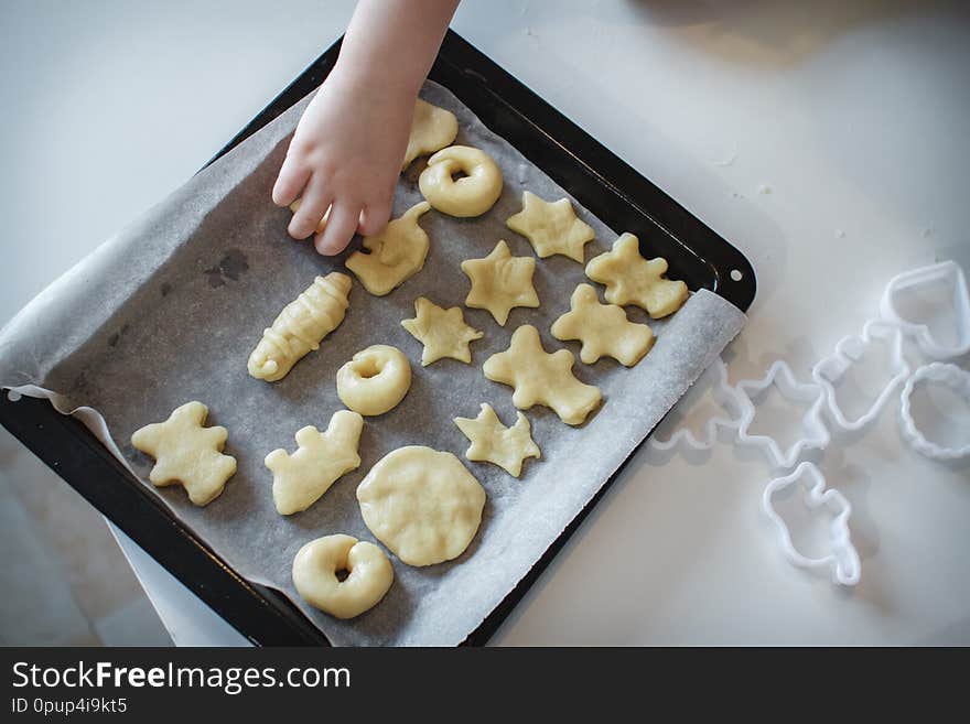 Two children put cookies on a baking sheet. homemade desserts. The view from the top. Close up