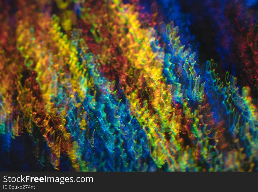 Defocused lights in motion. Swirled thin multicolor lines on dark background. Lens flare effect. Defocused lights in motion. Swirled thin multicolor lines on dark background. Lens flare effect.