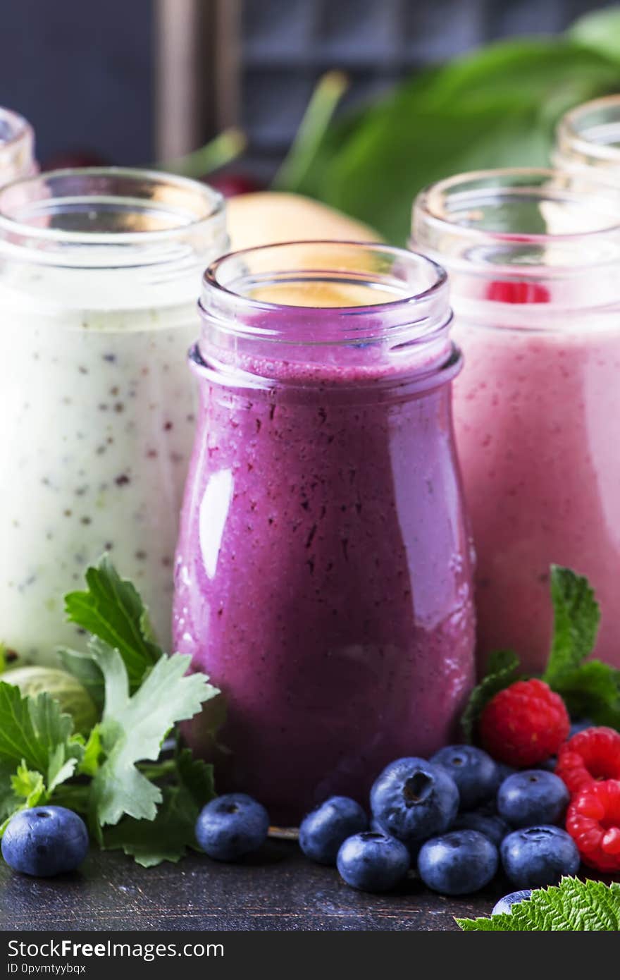 Berry fruit cokctalis, smoothies and milkshakes, fresh fruit and berries on  brown table, still life, selective focus