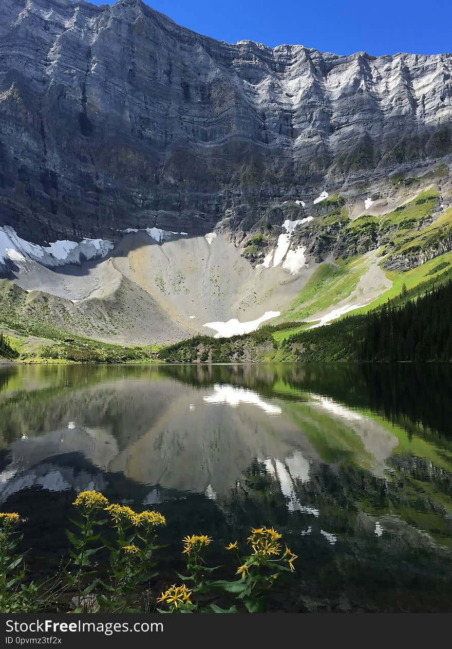 Beautiful alpine lake surrounded by mountain peaks and alpine meadows attracts tourists and outdoor activity lovers all year around. Beautiful alpine lake surrounded by mountain peaks and alpine meadows attracts tourists and outdoor activity lovers all year around.