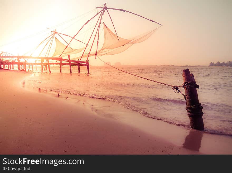 Amazing sunset colors of tropical beach. Ocean coast landscape with chinese fishing nets silhouette at Cochin Kochi. South India, Kerala, Kochin. Amazing sunset colors of tropical beach. Ocean coast landscape with chinese fishing nets silhouette at Cochin Kochi. South India, Kerala, Kochin