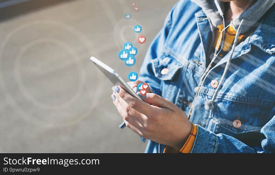 Young woman watches live stream while walking down city street