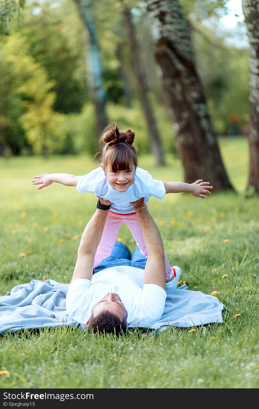 Happiness and harmony in family life. Happy family concept. Young mother and father with their daughter in the park. Happiness and harmony in family life. Happy family concept. Young mother and father with their daughter in the park