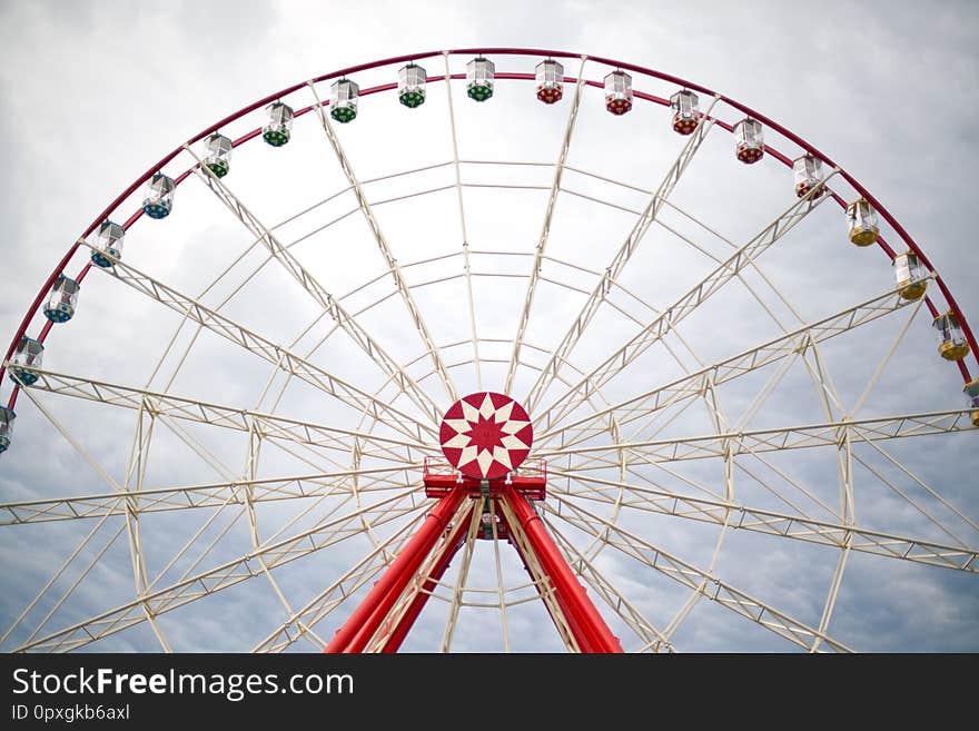 Ferris wheel in an amusement park on a background of clouds. Ferris wheel in an amusement park on a background of clouds