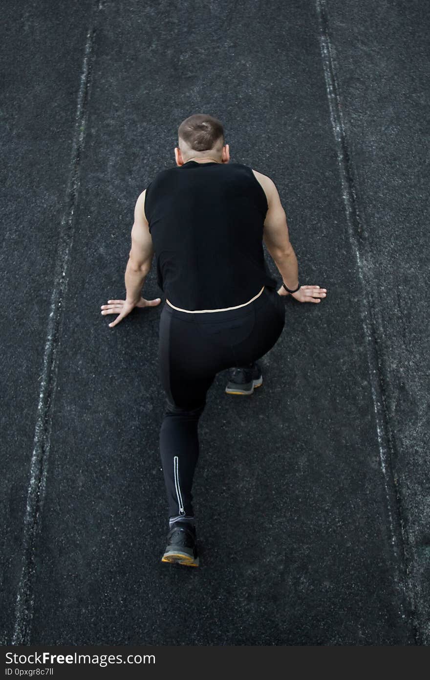 Caucasian man doing a sprint start. running on the stadium on a track. Track and field runner in sport uniform. energetic physical