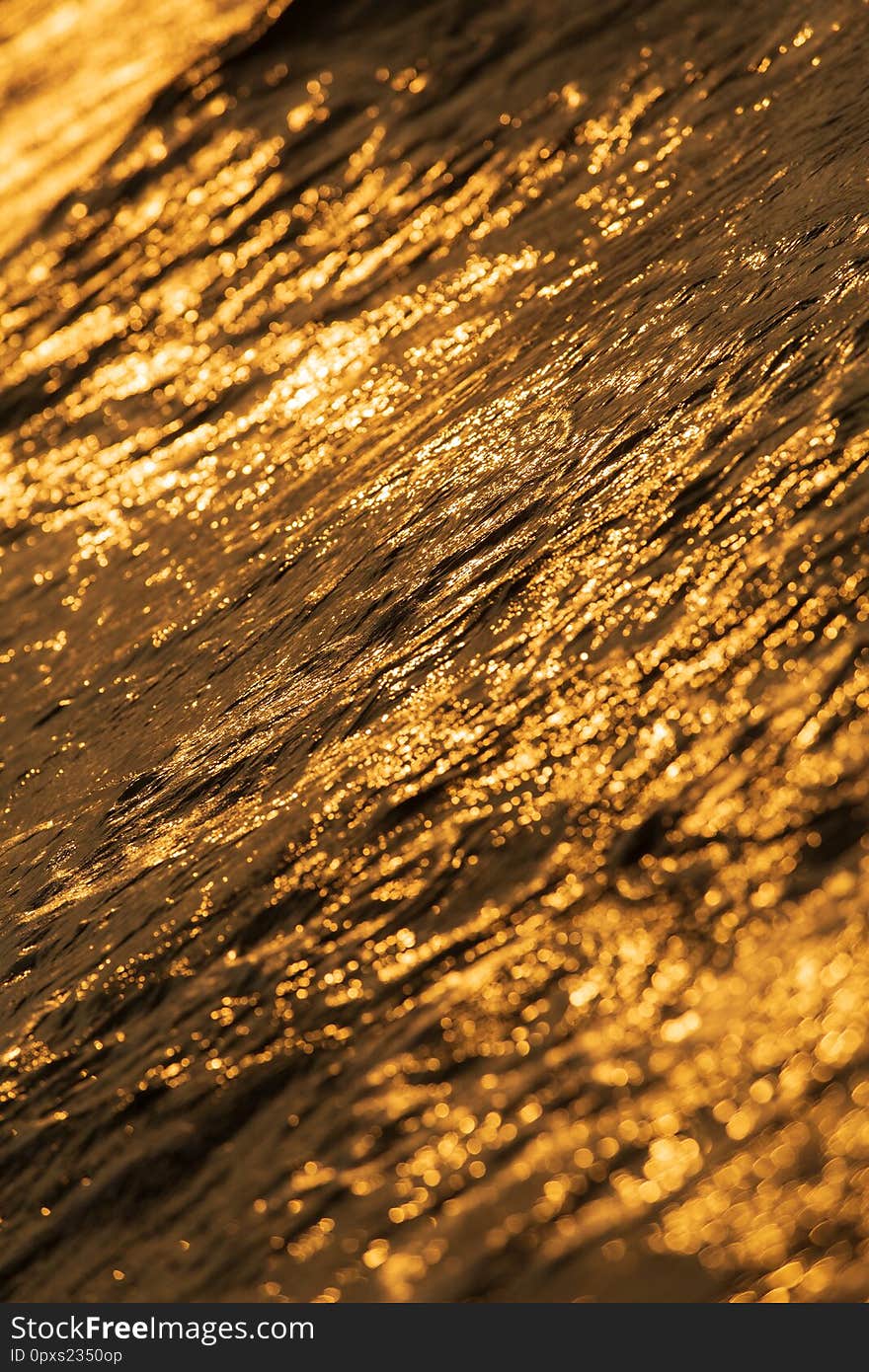 Texture of tropical sea water and wave in golden light of sunset. Texture of tropical sea water and wave in golden light of sunset