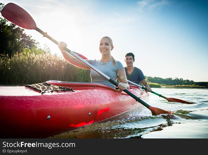 Portrait of smiling confident couple paddling over the idyllic lake. Portrait of smiling confident couple paddling over the idyllic lake