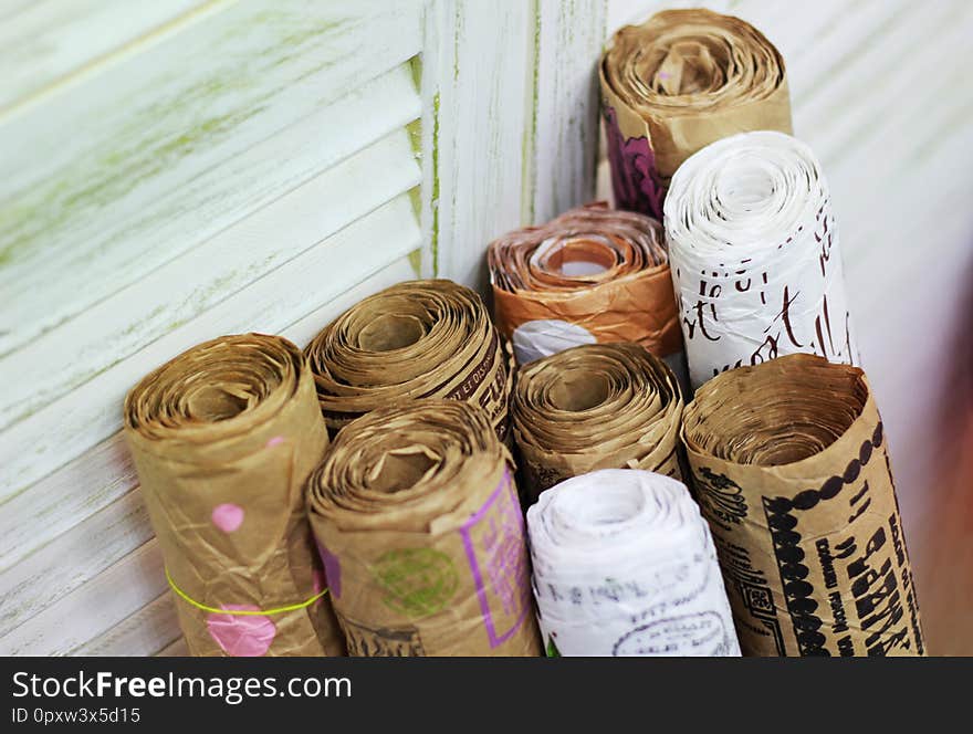 Kraft paper in rolls with vintage pattern for gift wrapping on the background of old painted blinds. Kraft paper in rolls with vintage pattern for gift wrapping on the background of old painted blinds