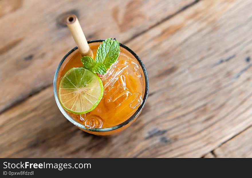 Ice cold sweet lemon tea drink  on the wooden table with outdoor sun lighting