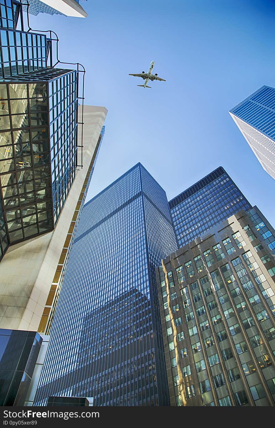 An airplane flies overhead Toronto skyscrapers. Skyscrapers in the financial district in downtown Toronto, Ontario, Canada