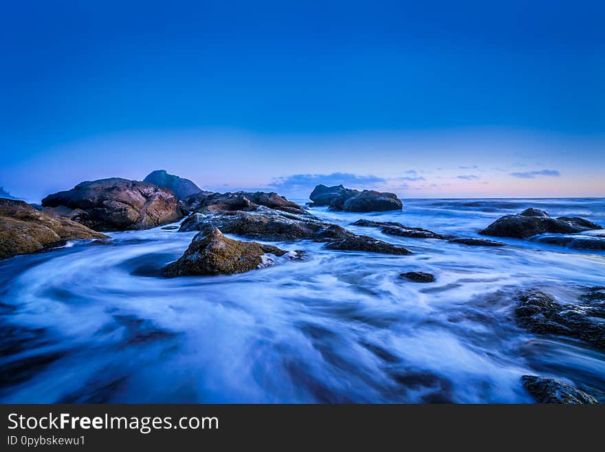 Long exposure of ocean water and rocks during blue hour photography. Long exposure of ocean water and rocks during blue hour photography