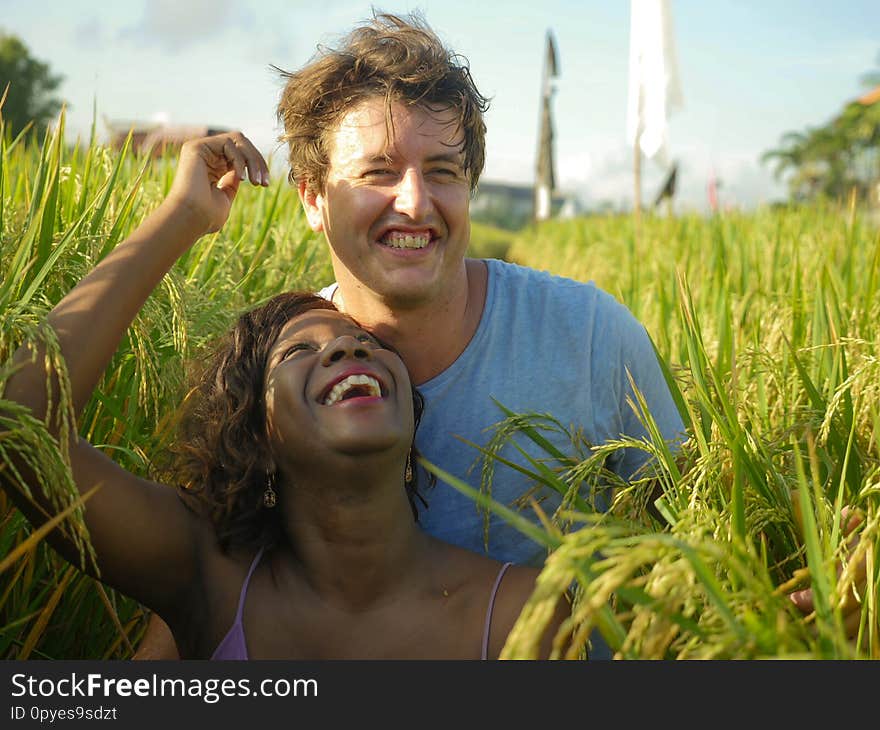 Young happy and beautiful mixed ethnicity couple with black African American woman and attractive Caucasian man cuddling and