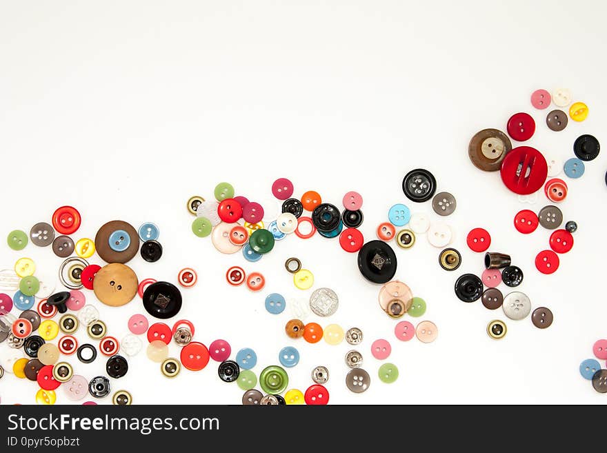 Flat lay with colorful sewing buttons, mock up, top view. Layout buttons mockup on blank white background for needlework, sewing, embroidery poster, banner. Empty space for text