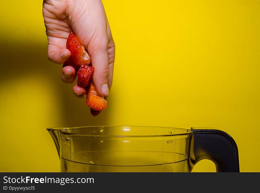 Putting fresh strawberry in glass blender with ice cream for making milkshake. Putting fresh strawberry in glass blender with ice cream for making milkshake