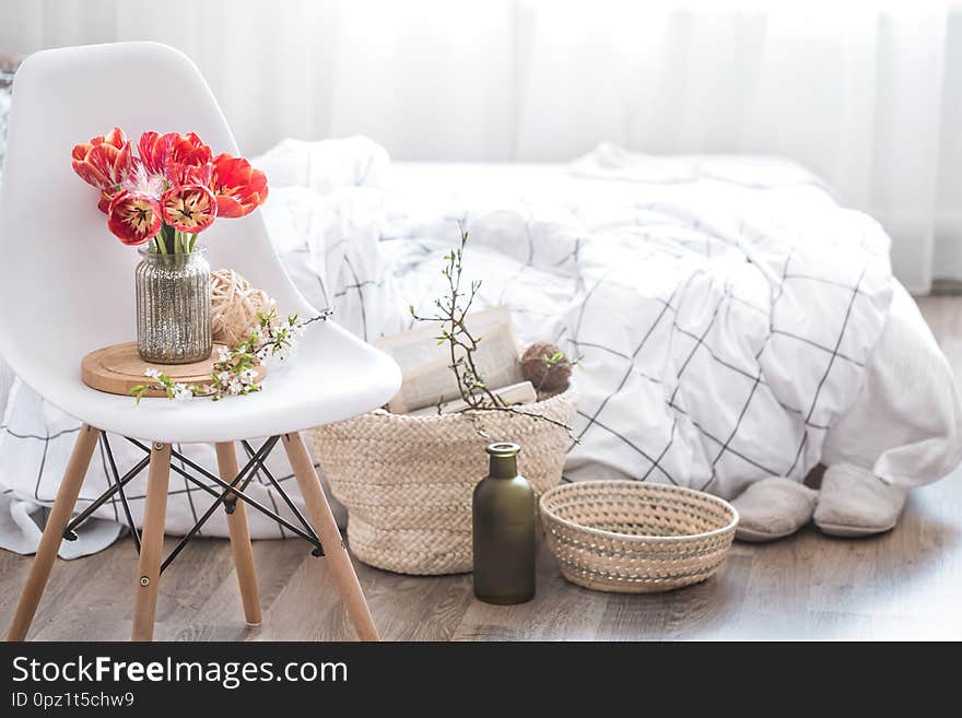 Objects of home cozy decor in the interior of the room .With beautiful red tulips .The concept of decor and home atmosphere. Objects of home cozy decor in the interior of the room .With beautiful red tulips .The concept of decor and home atmosphere