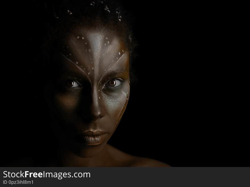 Portrait of beautiful African girl with traditional tribal paintings on her face on black background. Portrait of beautiful African girl with traditional tribal paintings on her face on black background