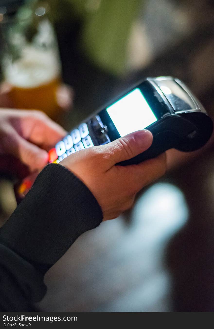 Cropped view of womens hand using credit card to make payment on Payment terminal in bar