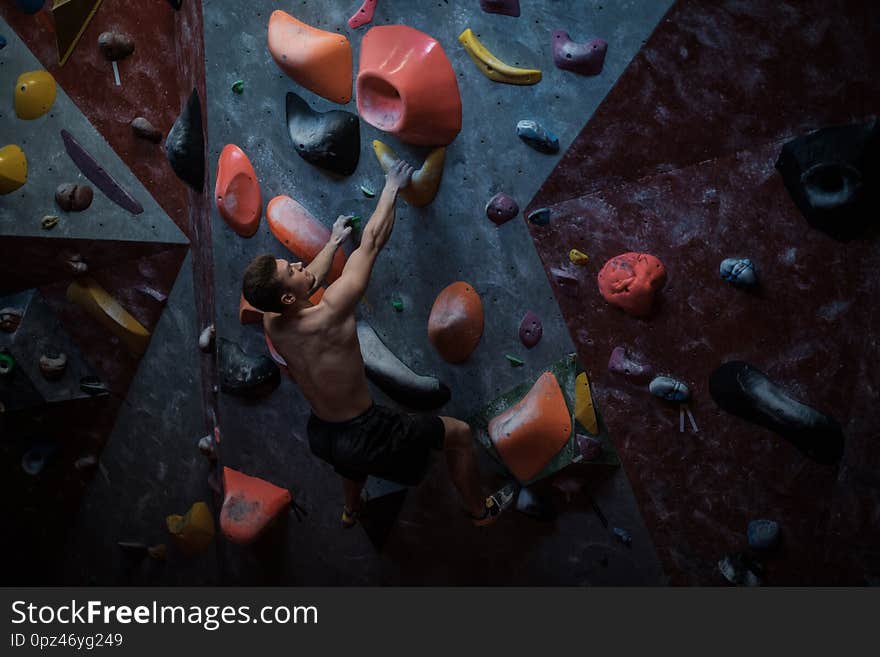 Athletic man practising in a bouldering gym.